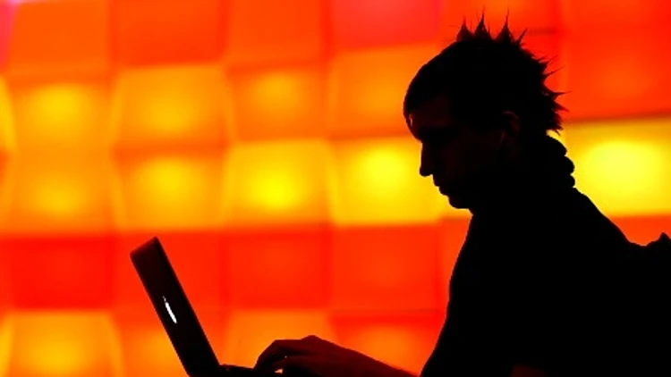 בחור משתמש במחשב ברקע כתום