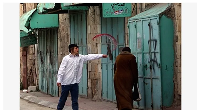 מתנחל שופך יין על פלסטינית, חברון, 2009