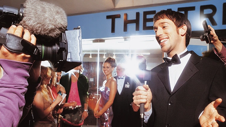 כתב טלוויזיה על השטיח האדום, גונב את אור הזרקורים לעצמו