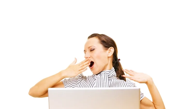 אשה מפהקת מול מחשב נייד