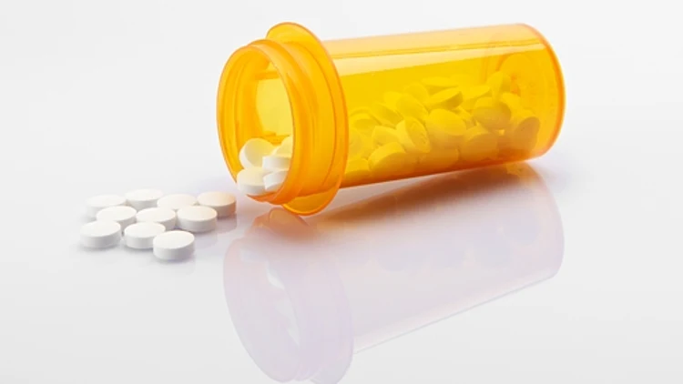 בקבוק עם תרופות נשפכות ממנו - אילוסטרציה