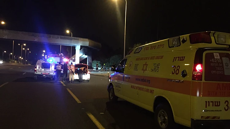 אמבולנס בזירת תאונת דרכים שהתרחשה בכביש 2 בסמוך למכון וינגייט, בה נהרג בן אדם שרכבו התהפך ועלה באש
