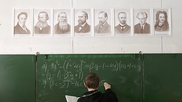 תלמיד מנסה לפתור תרגיל במתמטיקה על הלוח