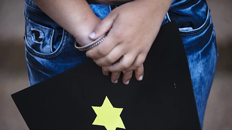 מפגין מול שגרירות גרמניה נגד הסופר גינתר גראס ביום השואה