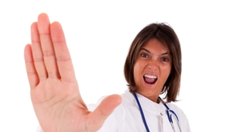 רופאה עצבנית עושה STOP עם היד