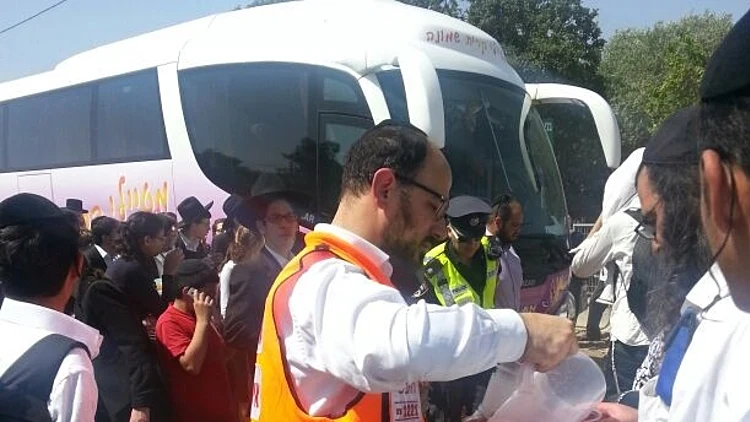 חובשי איחוד הצלה מחלקים משקה לחוגגים בהילולה בהר מירון
