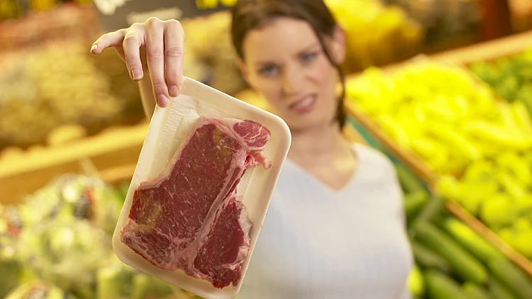 אישה מחזיקה סטייק בגועל