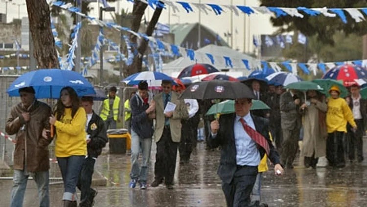 אנשים בגשם עם מטריות