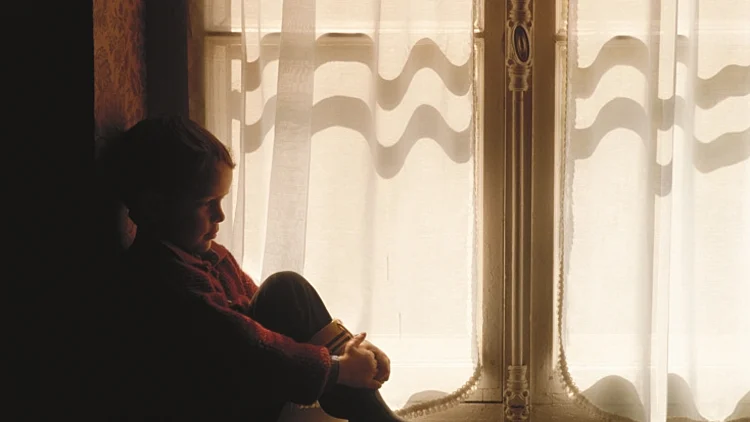 ילד יושב ליד חלון