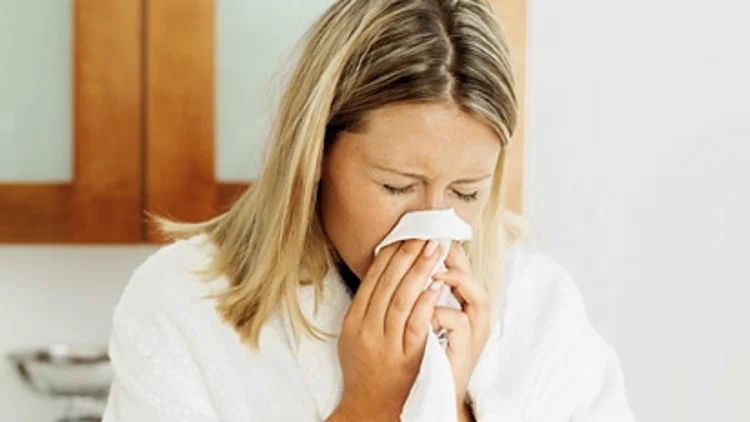 אישה מתעטשת