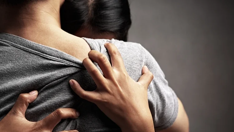 אשה מחבקת גבר מתוך צער ואבל