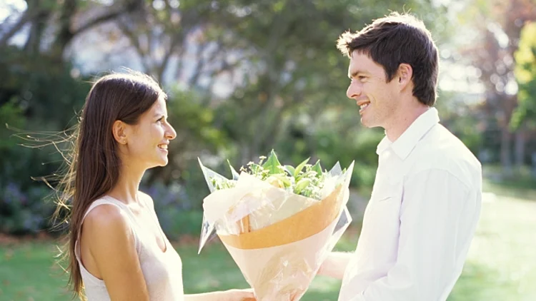 בחור נותן לחברתו זר פרחים