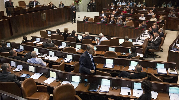 אחמד טיבי הולך במליאת הכנסת במהלך דיון, ב-2014