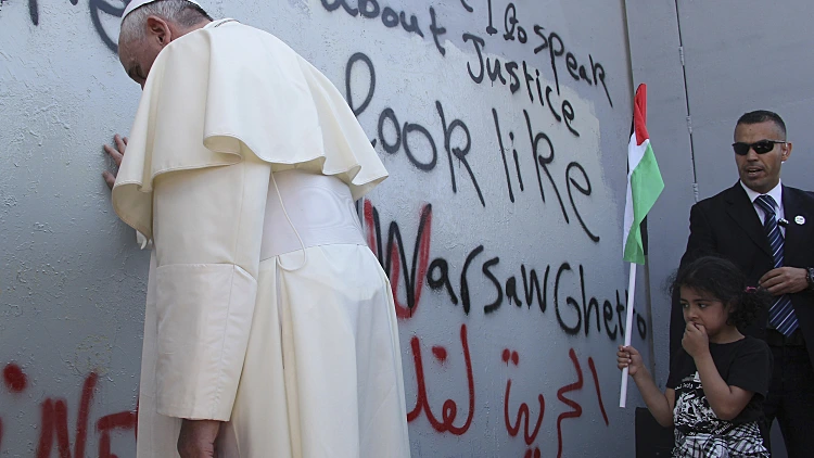 האפיפיור פרנציסקוס מתפלל בחומת ההפרדה