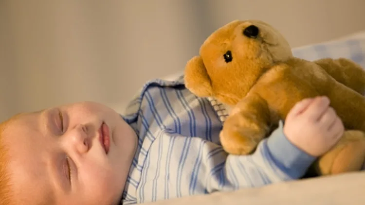 תינוק ג'ינג'י ישן עם דובי