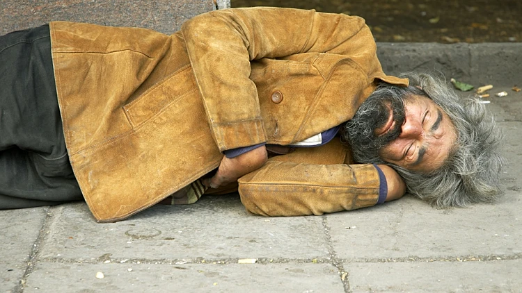 הומלס שוכב על מדרכה