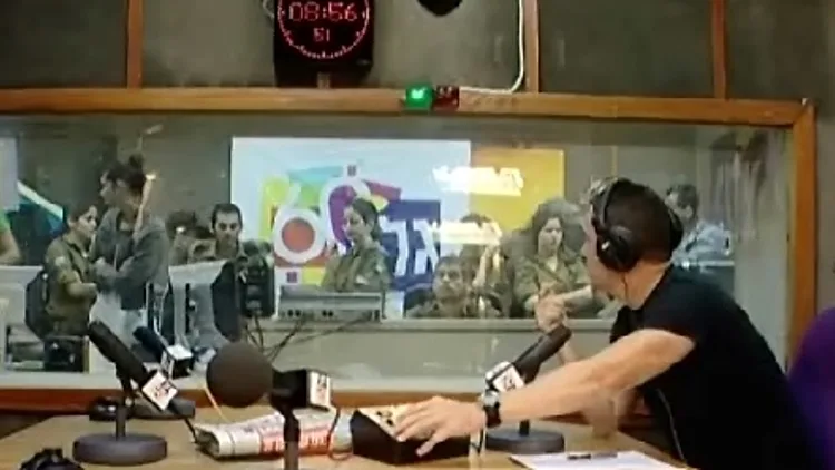 אולפן גלי צה"ל בעת שידור ביום השידורים המיוחד לציון 60 שנה לייסוד התחנה, יעקב אילון ליד המיקרופון וחיילים מאחורי השמשה