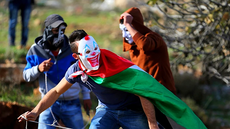 פלסטיני מיידה אבנים בהפגנה ליד רמאללה