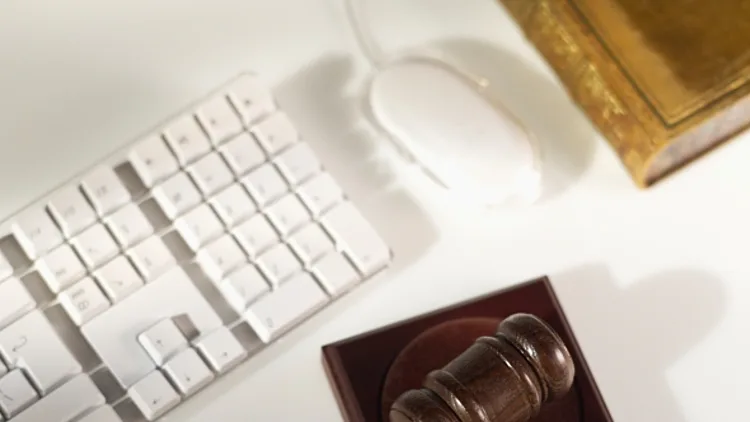 פטיש שופטים מונח לצד מקלדת ומחשב
