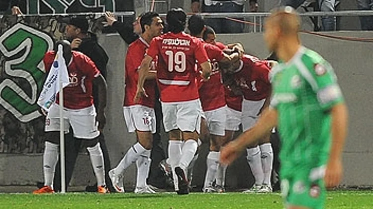 שחקני הפועל חוגגים ברקע יניב קטן