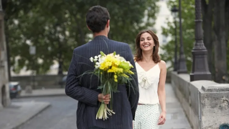 פגישה ברחוב כשהגבר מביא פרחים