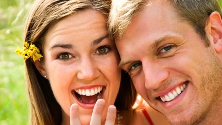 בחורה עם החבר מציגה טבעת אחרי הצעת נישואים.