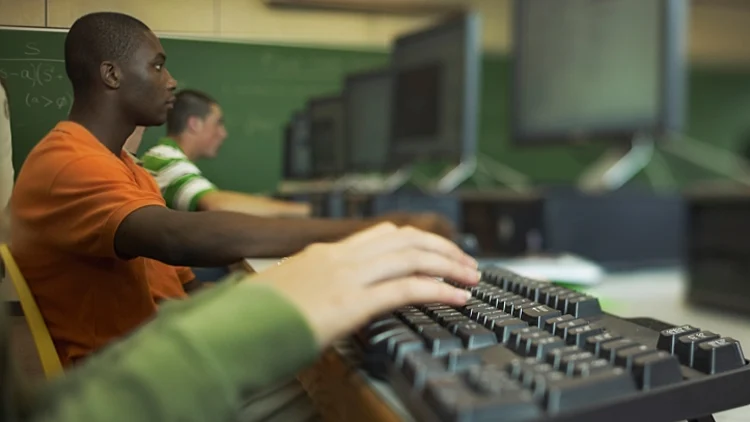 יד מקלידה במה שנראה כמו חוות מחשבים. תמונה רוחבית