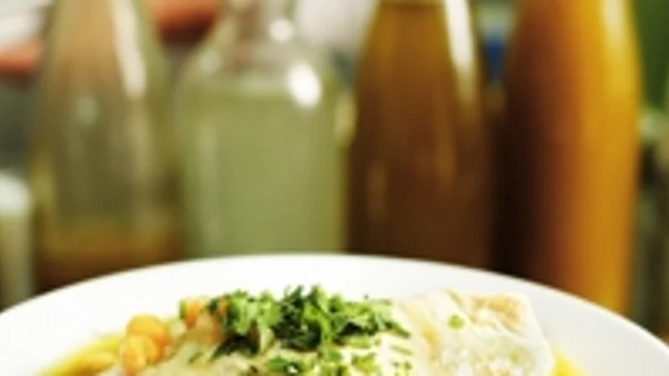 ממרח חומוס בצלחת עם גרגירי חומוס, שמן זית ועשבי תיבול - פטרוזיליה