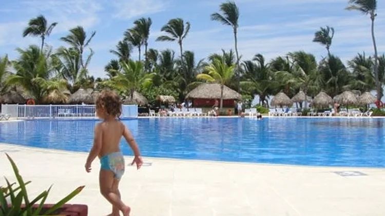 תינוקת משוטטת על החוף באיים הקריביים