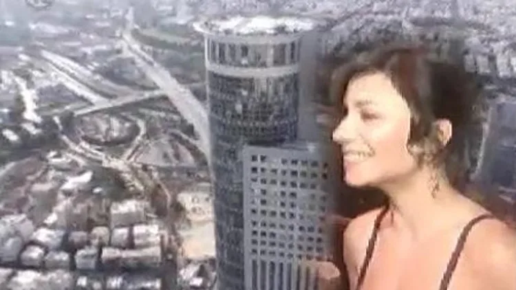 נינט טייב על רקע מגדל יוקרה תל אביבי