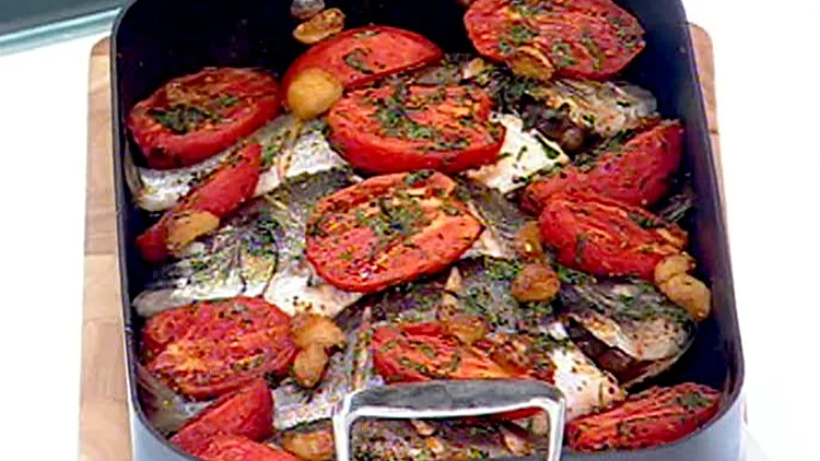 אהרוני מכין דניס שלם אפוי עם עגבניות לחות