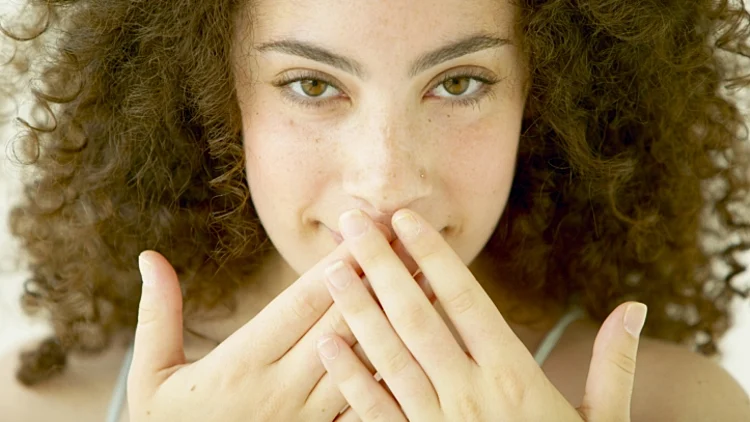 בחורה מכסה את הפה בידיים