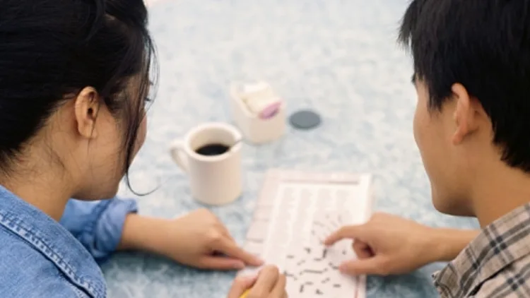 זוג ממלא תשבץ על כוס קפה