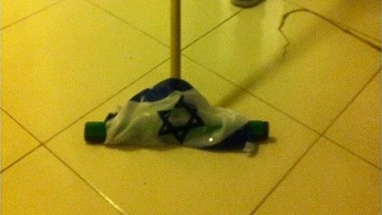 יהונתן שפיגלמן שוטף ריצפה עם דגל ישראל