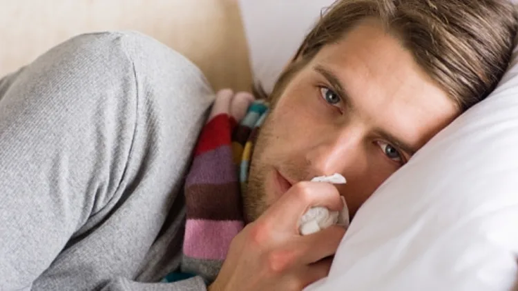 גבר חולה שוכב במיטה עם טישו