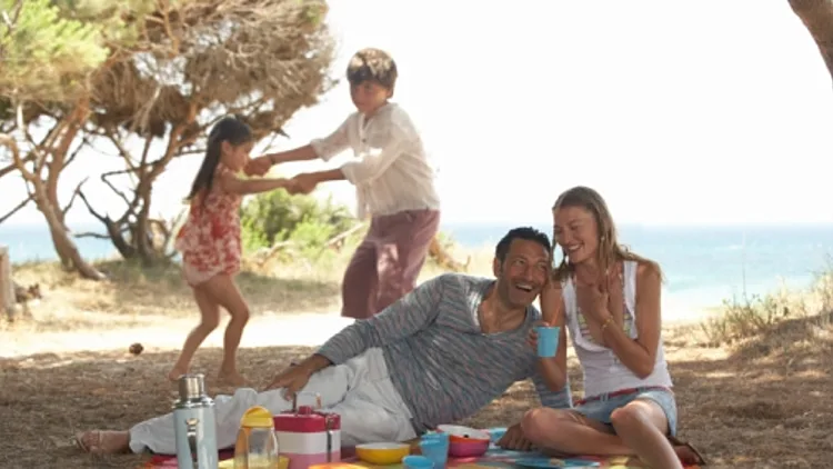 משפחה עושה פיקניק על חוף הים