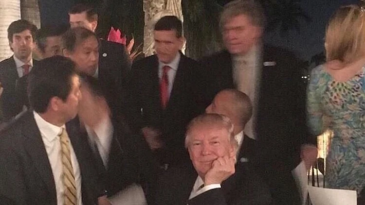 טראמפ עוצר לתמונה בעוד המשלחת מאחוריו נסערת