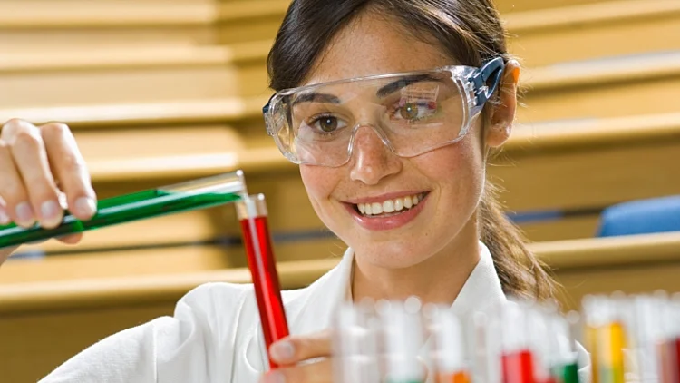 מדען מביט במבחנות צבעוניות