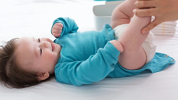 החלפת חיתול לתינוק על משטח החתלה