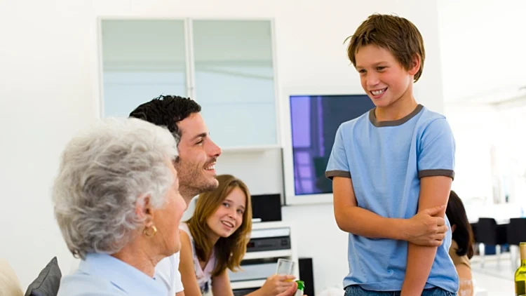 אילוסטרציה מבוכה והסמקה. ילד מסמיק ומחייך כשהוא עומד נבוך מול שלושה מבוגרים שמראיינים אותו. ועדת קבלה או משפחה