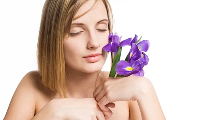 אישה מריחה פרחים