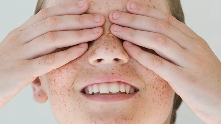 ילדה מכסה עיניים בידיים