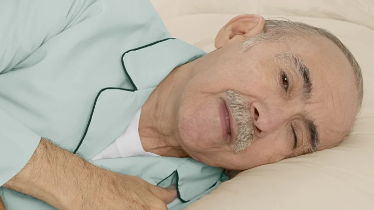 איש זקן שוכב במיטה בפיג'מה
