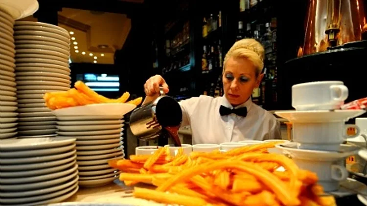 מלצרית מרימה צלחת צ'יפס במסעדה בריו דה ז'ה נרו