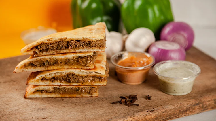 Stuffed,minced,meat,qeema,naan,with,spicy,sauces,and,ingredients