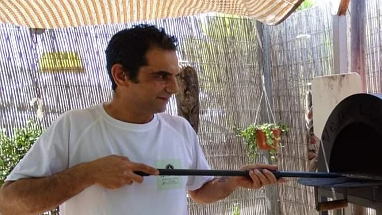 עמיר דוייב אופה בחצר עובד על הטאבון