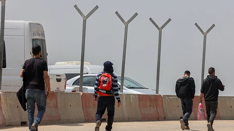 פלסטינים חוצים את הגדר בדרכם לישראל