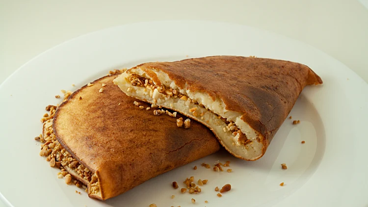 Asian,pancake,with,peanut,and,sugar,fillings,on,a,white