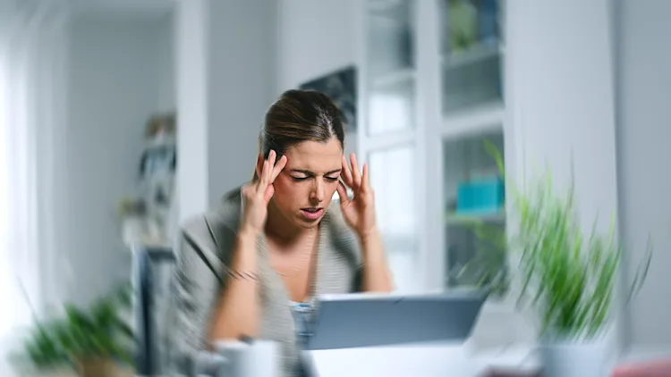 Sick,dizzy,young,woman,suffering,headache,while,working,on,her