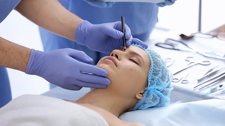 Plastic,surgeon,drawing,marks,on,female,face,in,clinic